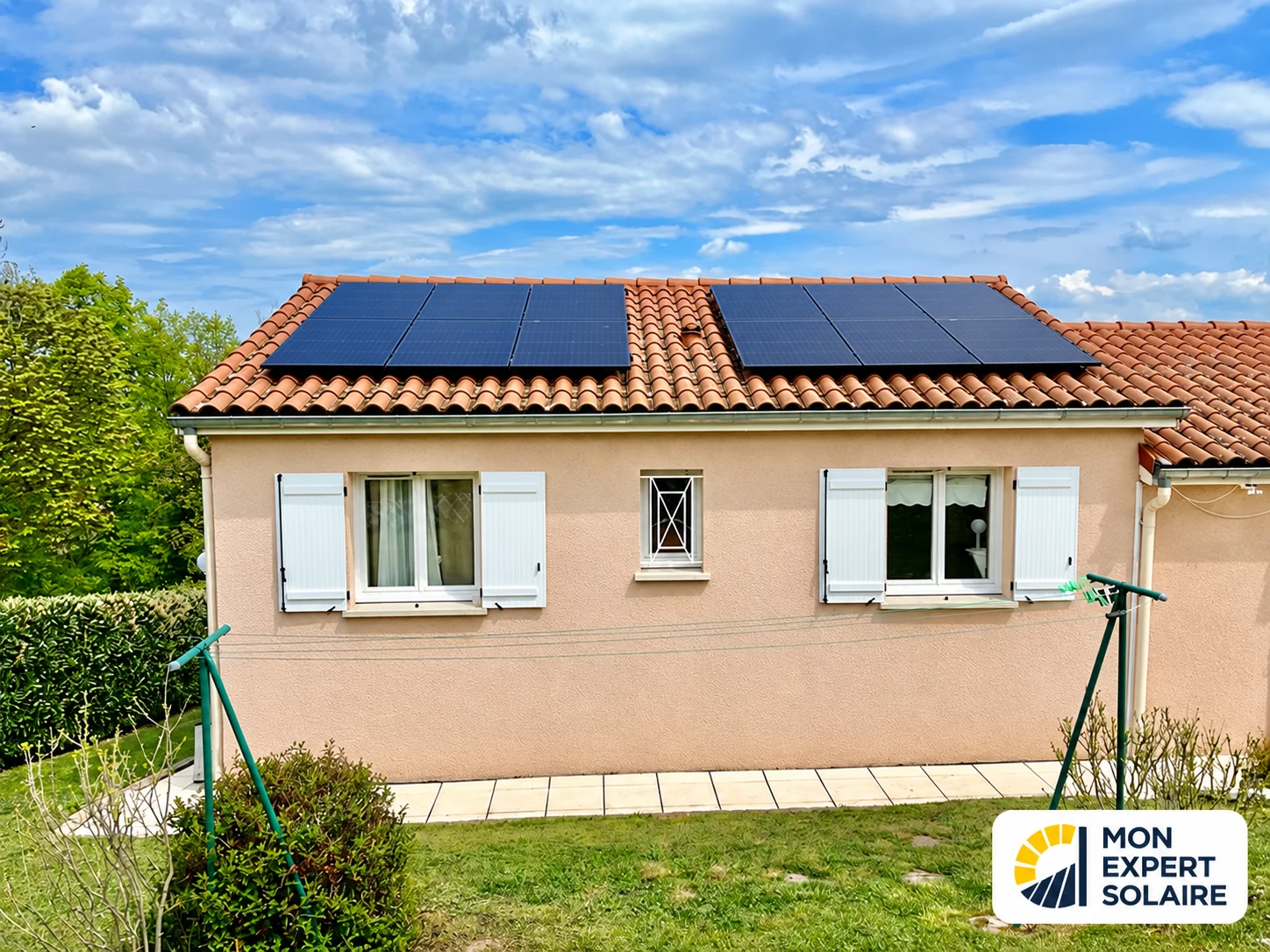 Façade d’une maison avec deux champs de panneaux solaires sur la toiture en tuiles.